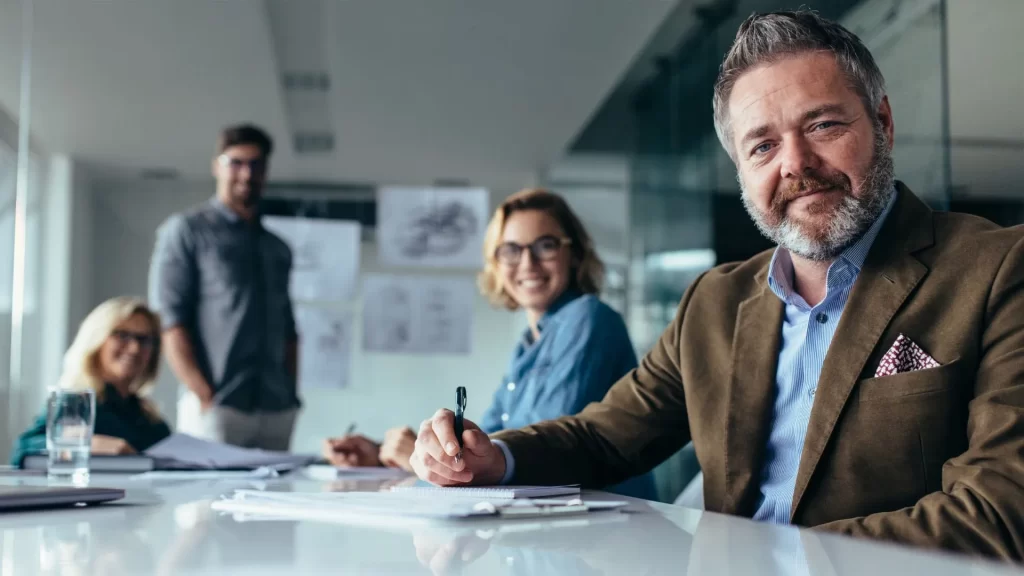 A team of four SEO professionals in an office setting are looking at the camera.