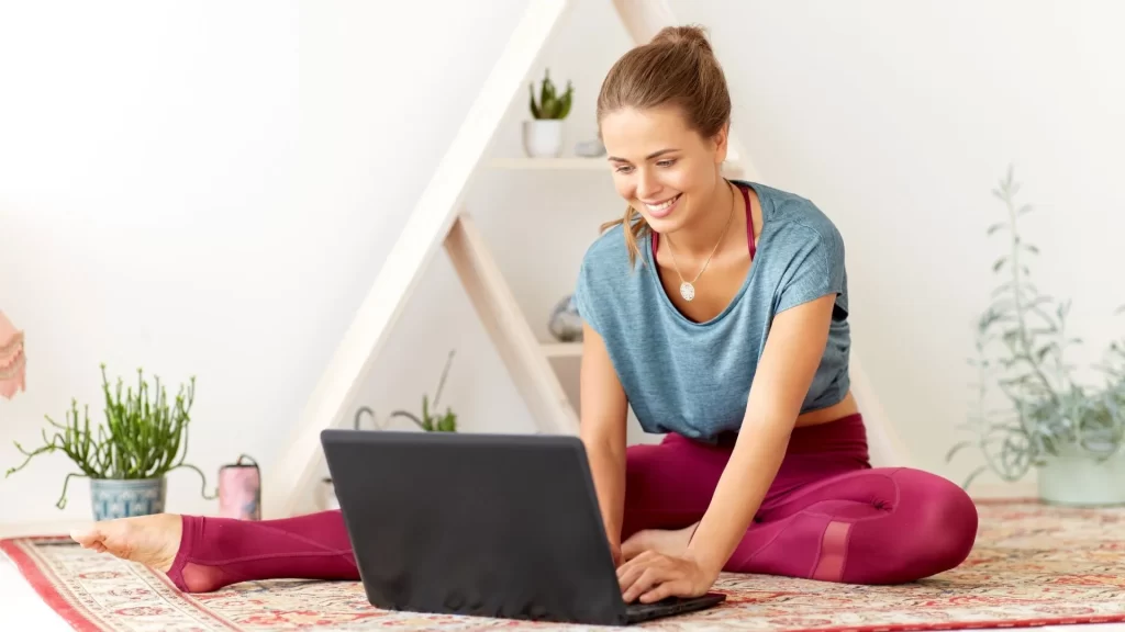 A woman in gym clothes using her laptop.