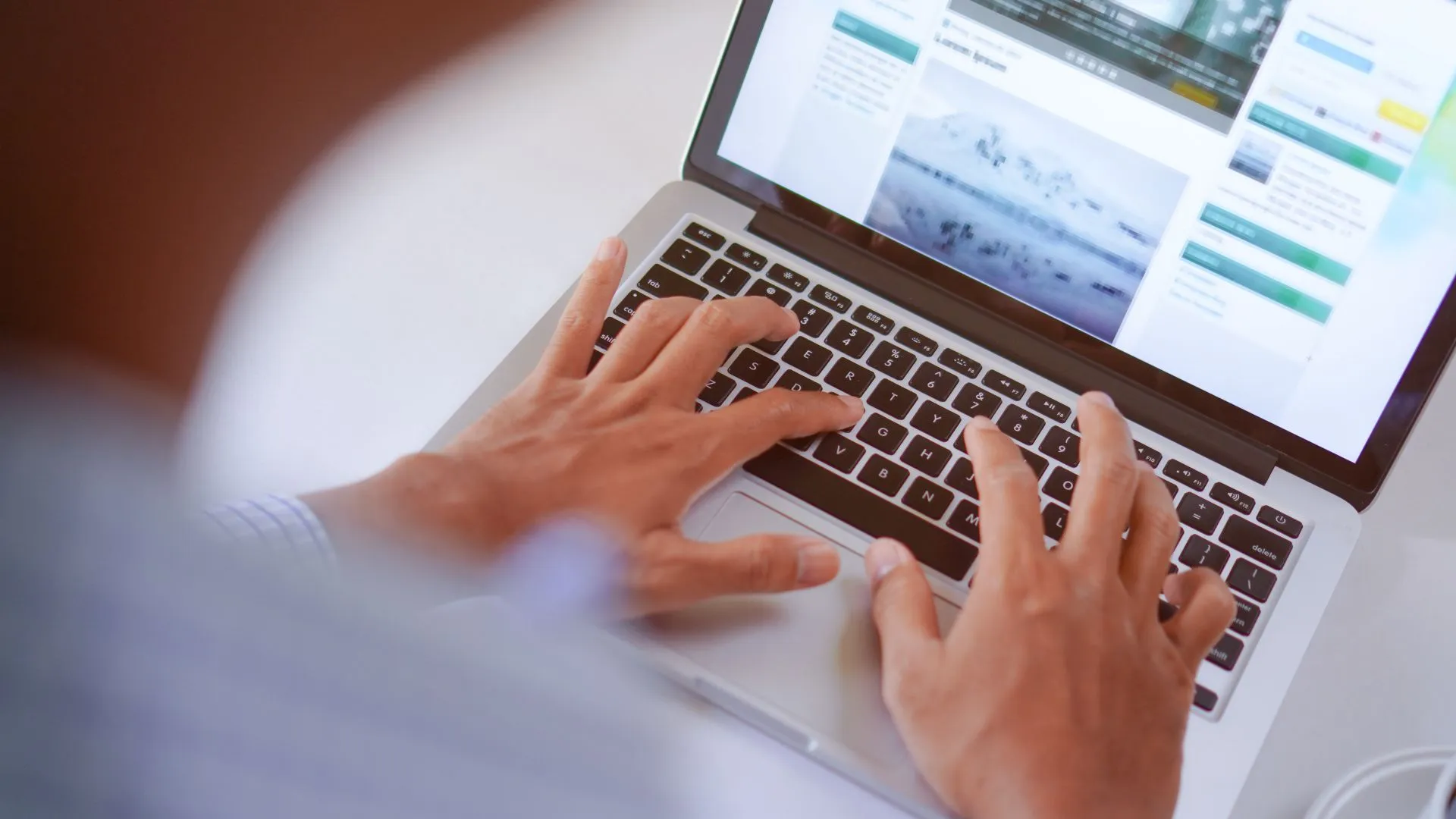 Man’s hands seen typing on a laptop