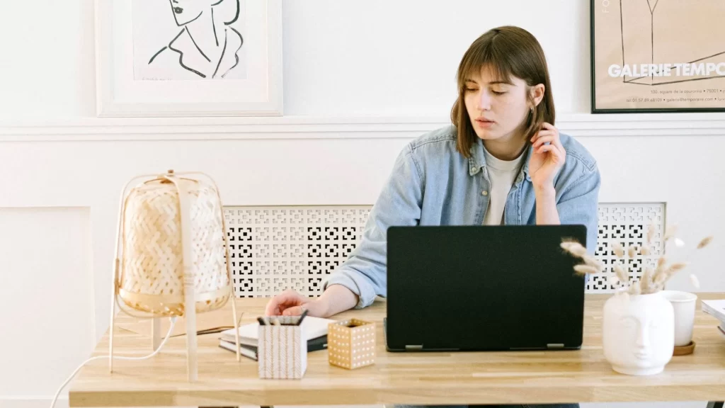 A woman using their laptop to think of SaaS email marketing strategies