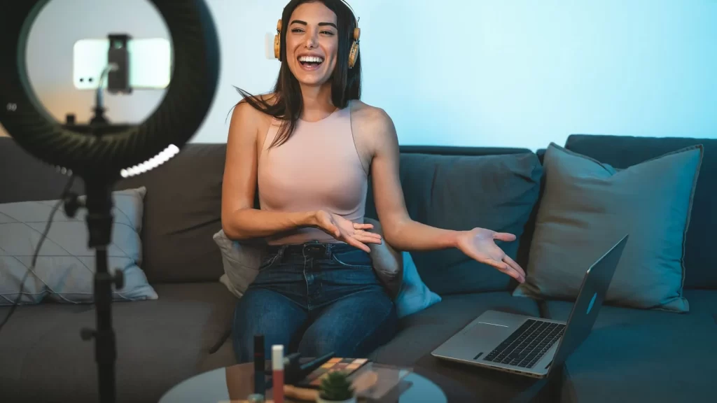 A female influencer pointing to her laptop, presumably showing off a SaaS service to her followers