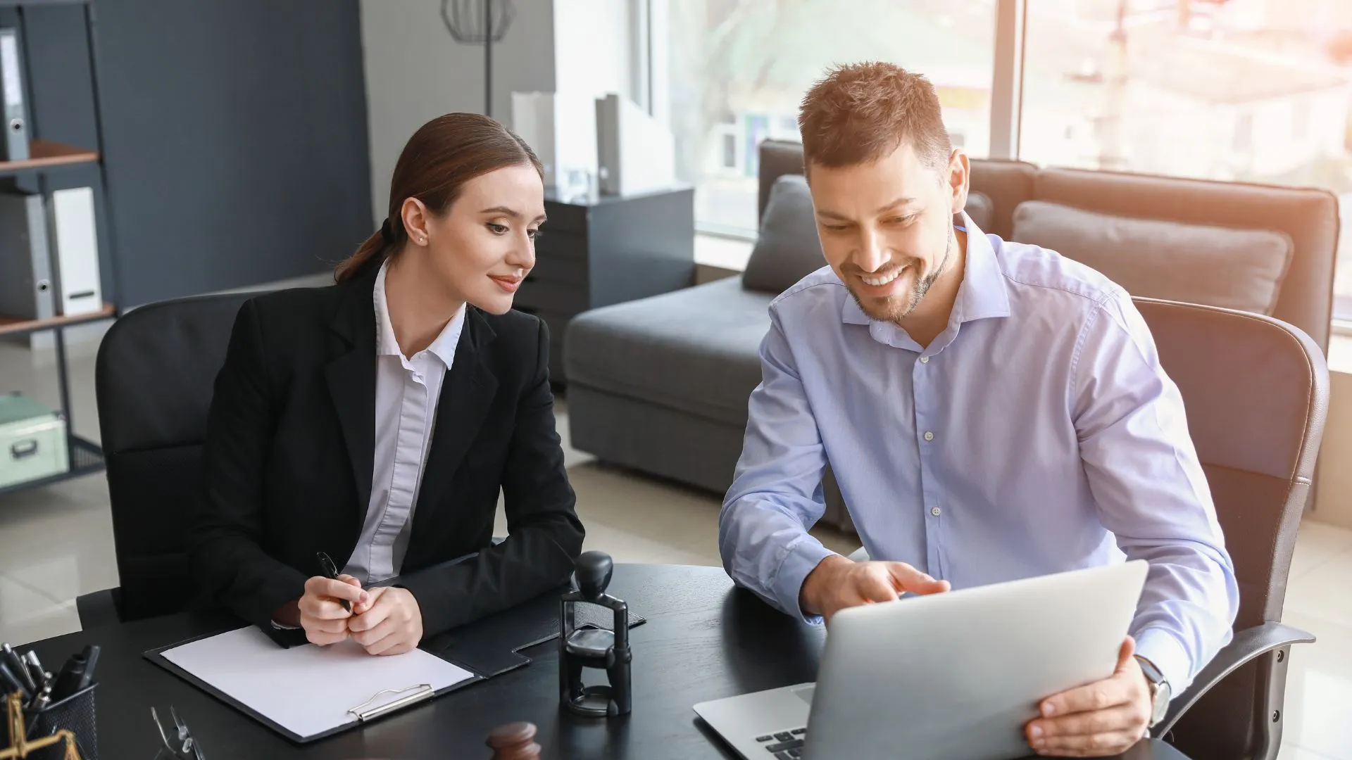 Two lawyers smiling at something on a laptop screen, presumably law firm email marketing materials