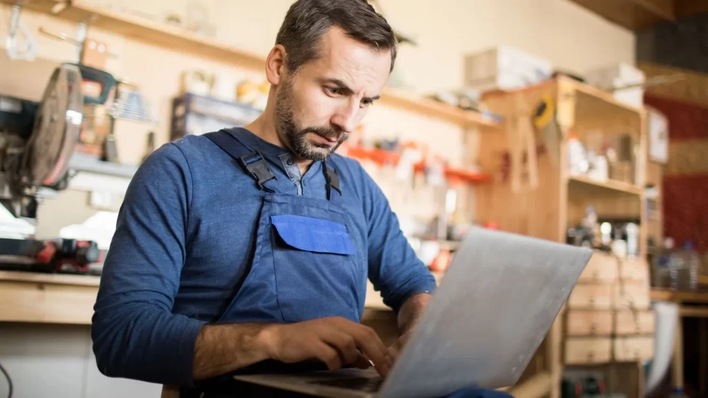 A male business owner contemplating if he realls needs a content marketing strategy for local SEO while using his laptop